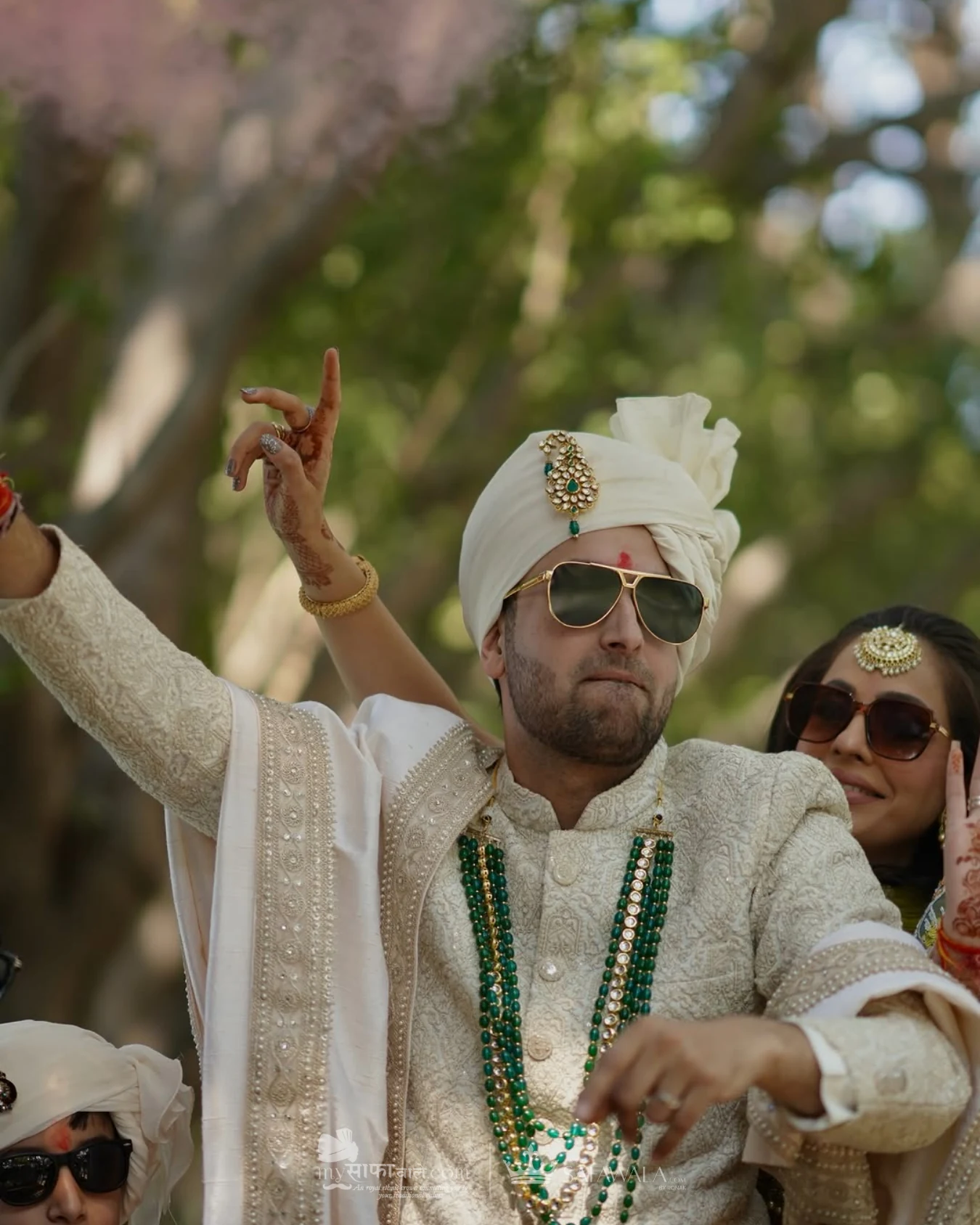 Groom in an ivory wedding safa with emerald jewellery for Adyar